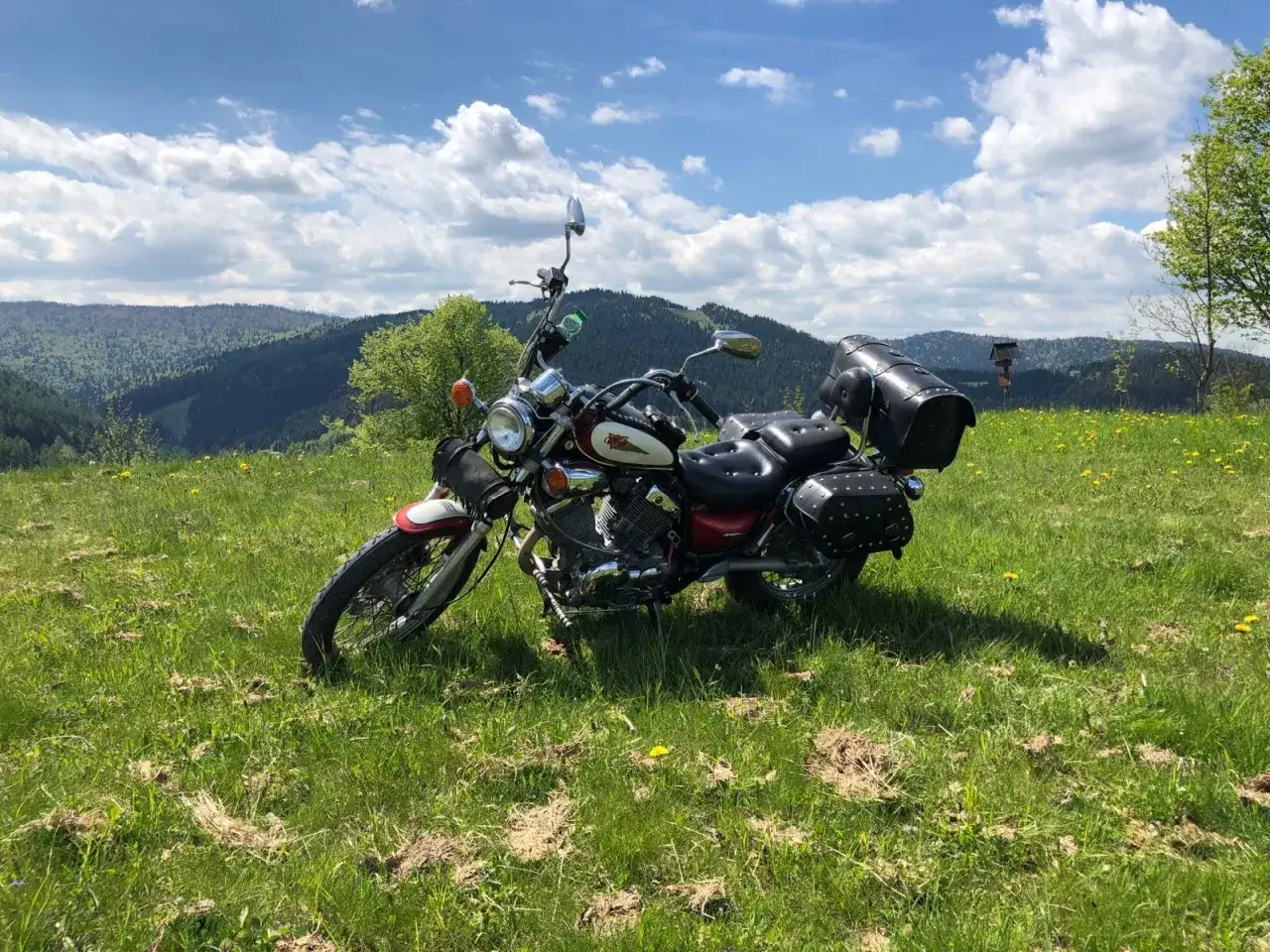 Motocykl czeka na odkrywanie malowniczych tras motocyklowych w Małopolsce. W tle góry i błękitne niebo.