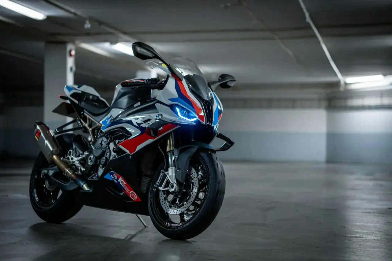Sportowy motocykl BMW XR w barwach M, z agresywnym przodem i wydechem Akrapovič, gotowy do jazdy.