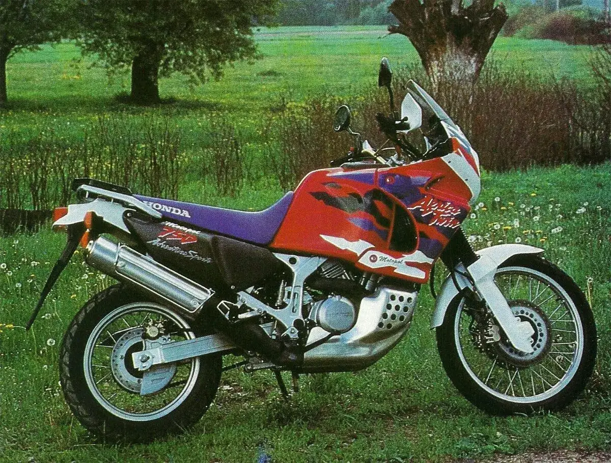 Honda Africa Twin 750, gotowy na przygodę, stoi na zielonej łące.