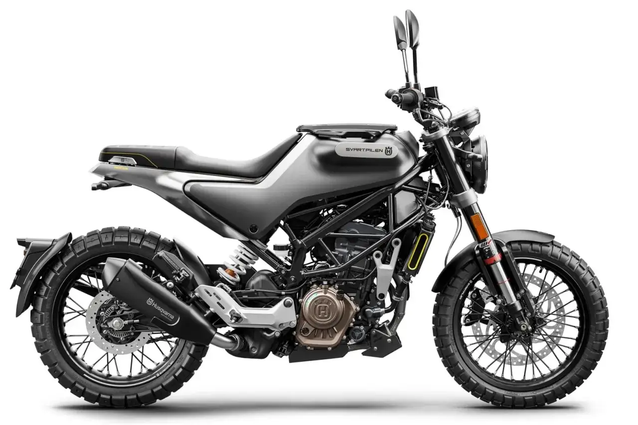 Szary motocykl Husqvarna Svartpilen 125 z czarnym wydechem i oponami terenowymi. Idealny do miejskich dżungli i poza asfaltem.