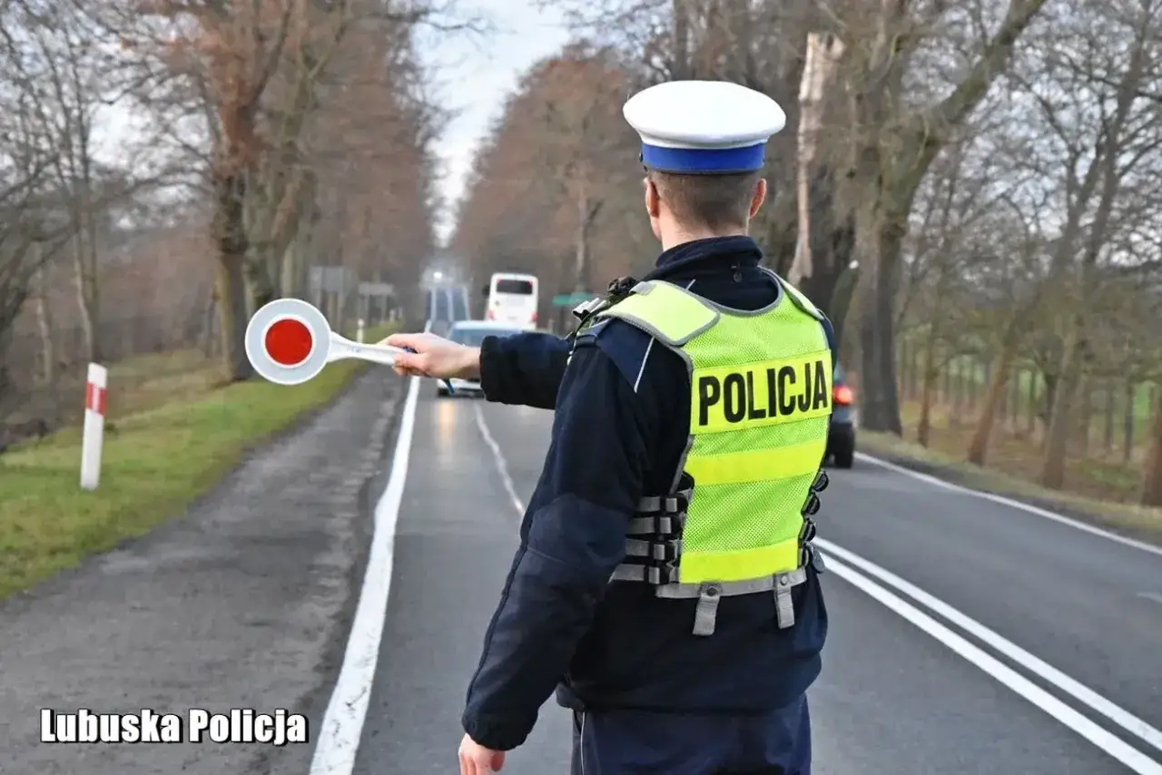 Policjant w kamizelce odblaskowej z napisem 