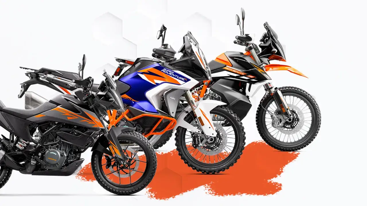 Trzy motocykle KTM Adventure w różnych kolorach: szary z pomarańczowymi akcentami, niebiesko-biały z pomarańczowymi detalami i czarno-pomarańczowy. Gotowe na każdą przygodę!