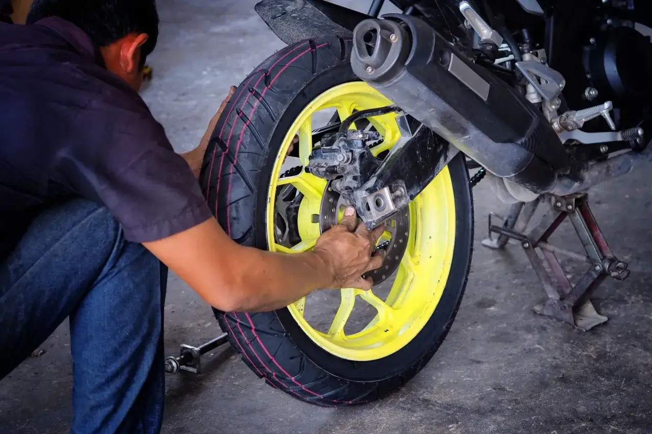 Mechanik wymienia oponę motocyklową. Sprawdź wymiana opon motocyklowych cena i umów się na serwis.