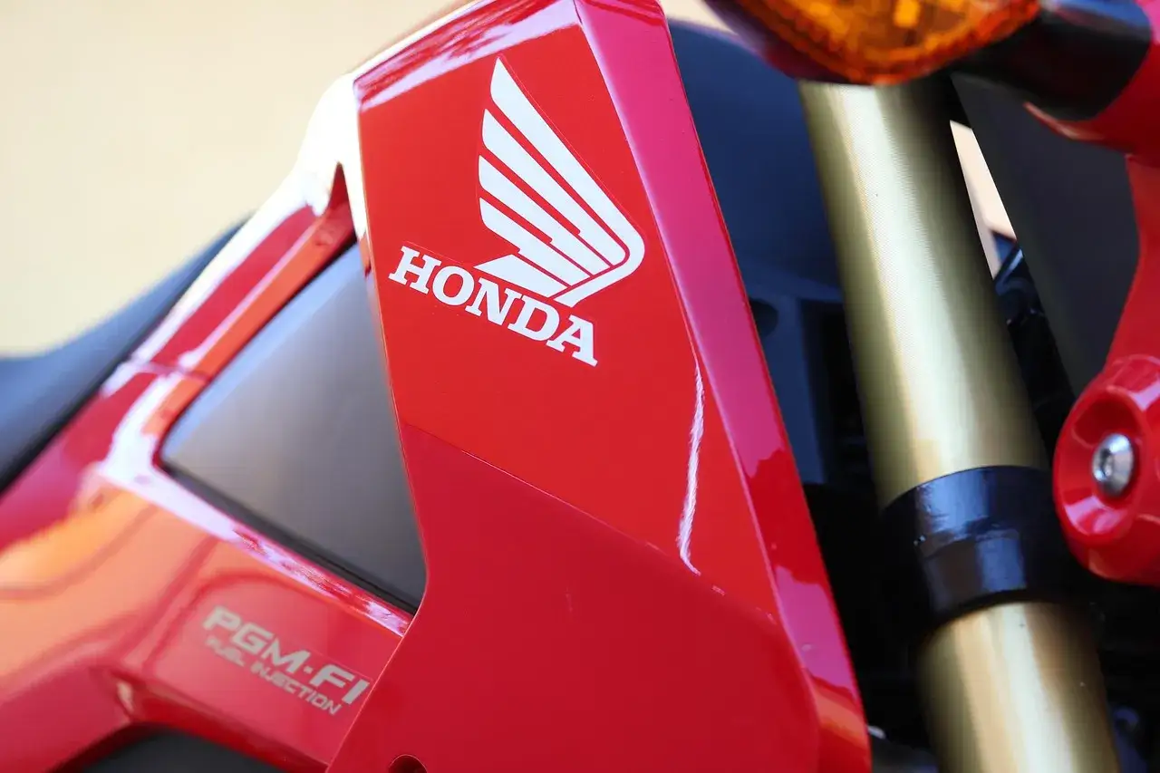 Czerwony motocykl Honda z logo i napisem PGM-FI. Pamiętaj o regularnych przeglądach, co ile przegląd motocykla 125?