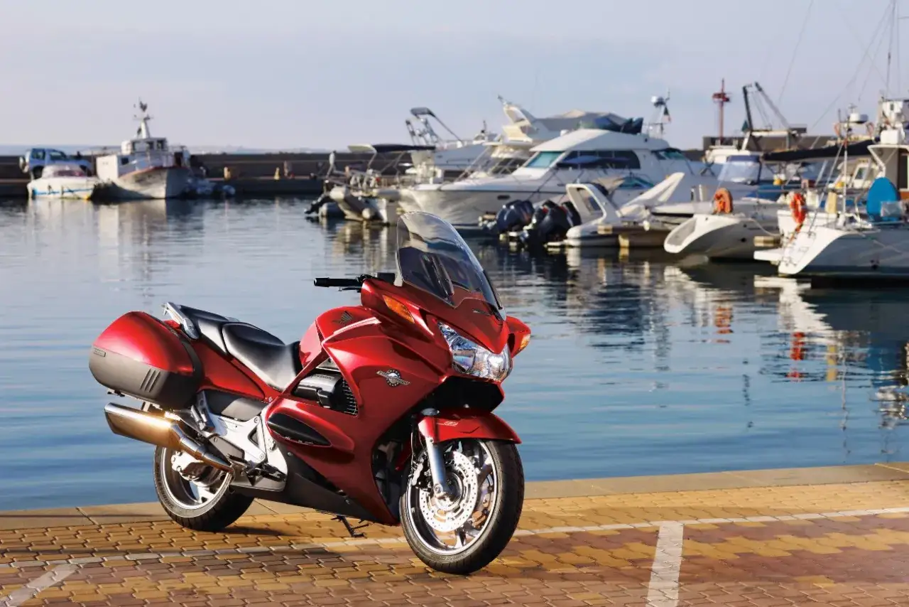 Czerwona Honda ST 1100 w marinie. Czy warto kupić ten motocykl? Zapytaj właściciela, który właśnie wrócił z rejsu.
