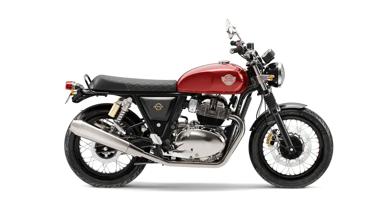 Czerwony Royal Enfield Interceptor 650 z chromowanymi elementami i czarnym siedzeniem, gotowy na przygodę.