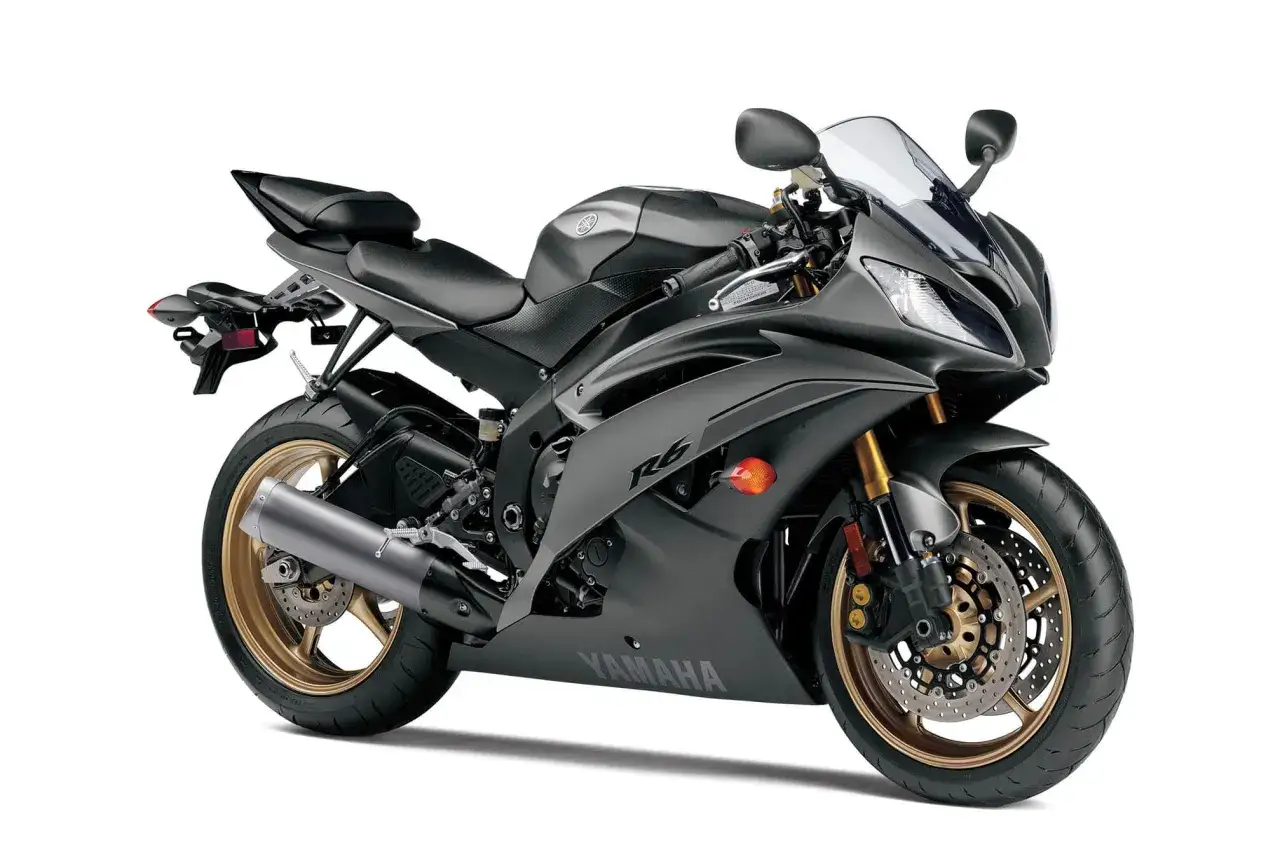 Czarny motocykl sportowy Yamaha R6 z silnikiem rzędowa 6, złotymi felgami i sportowym wydechem.