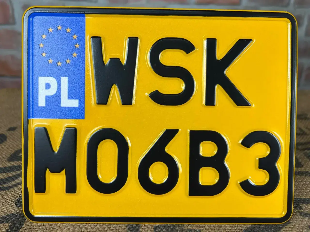 Żółta tablica rejestracyjna z oznaczeniem PL i numerem WSK MO6B3.