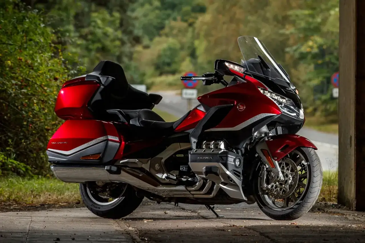 Lśniący, czerwony motocykl Honda Goldwing z bagażnikami, gotowy na długą podróż.